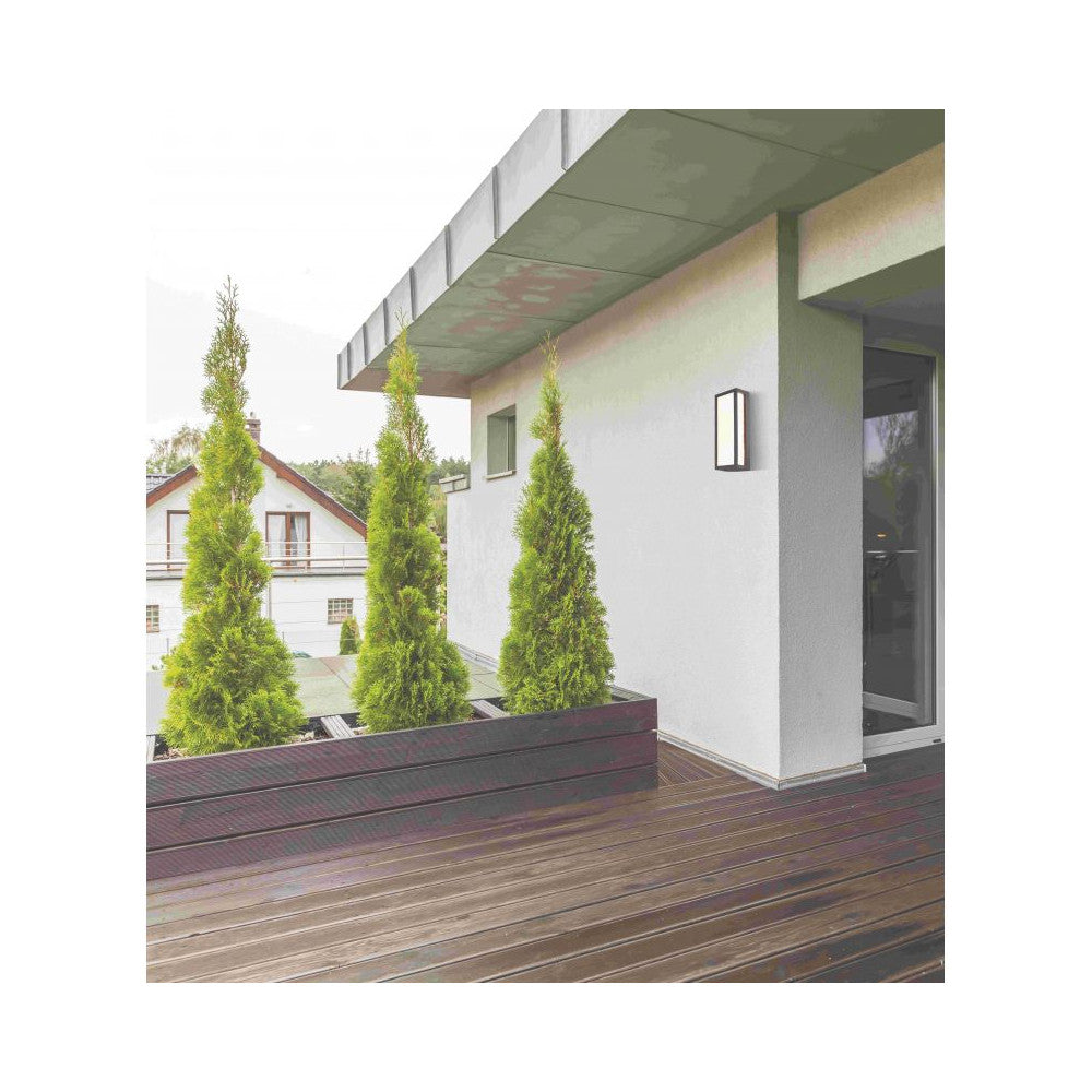 Mise en ambiance de l'applique noire sur une façade extérieure près d'une terrasse.