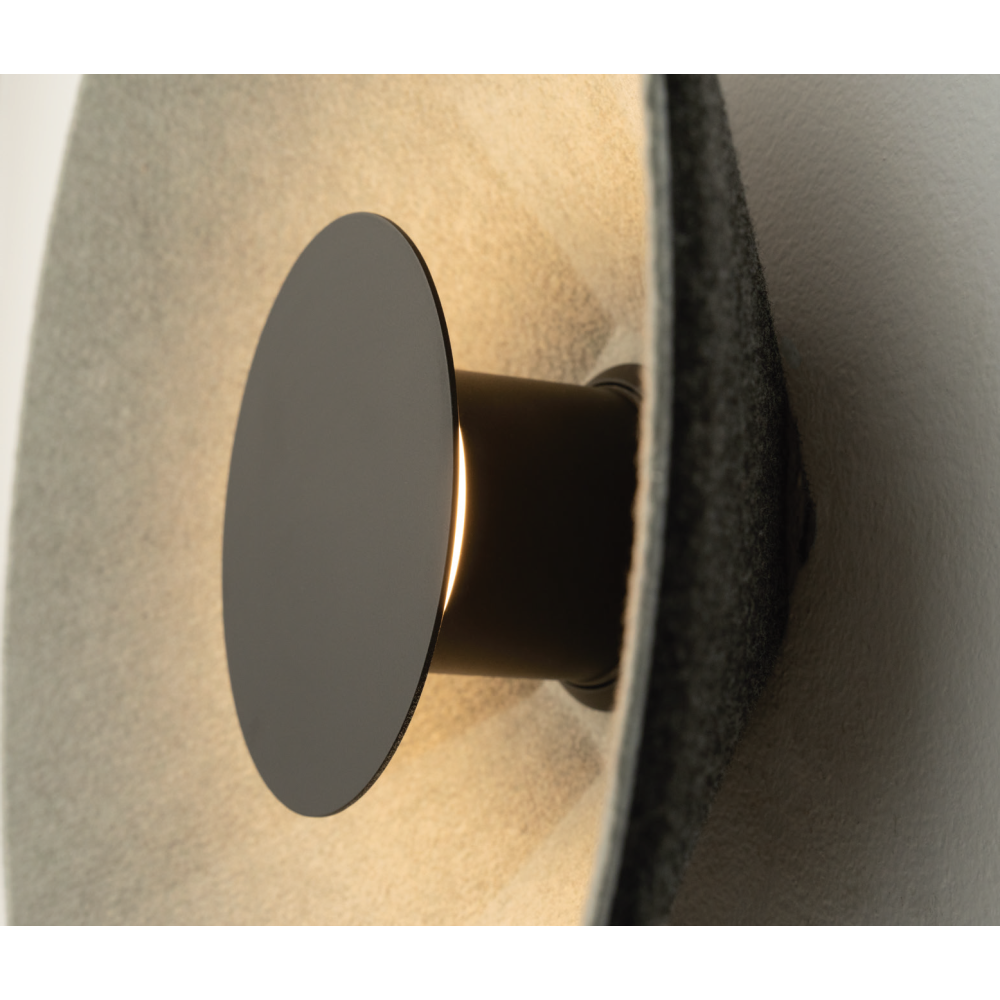 Détail rapproché du disque noir central et de sa base cylindrique éclairée