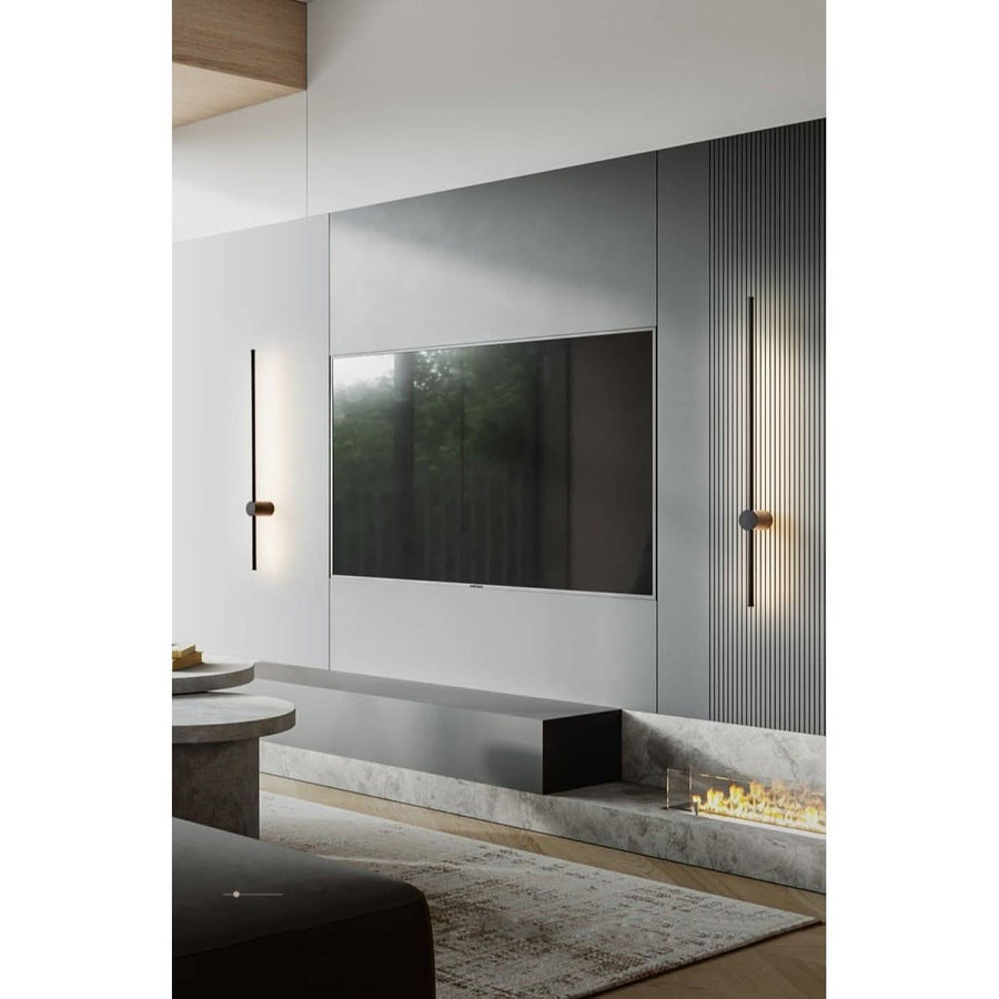 Applique murale Gravity noire LED dans un salon design avec cheminée, éclairage d'ambiance – Designix.fr