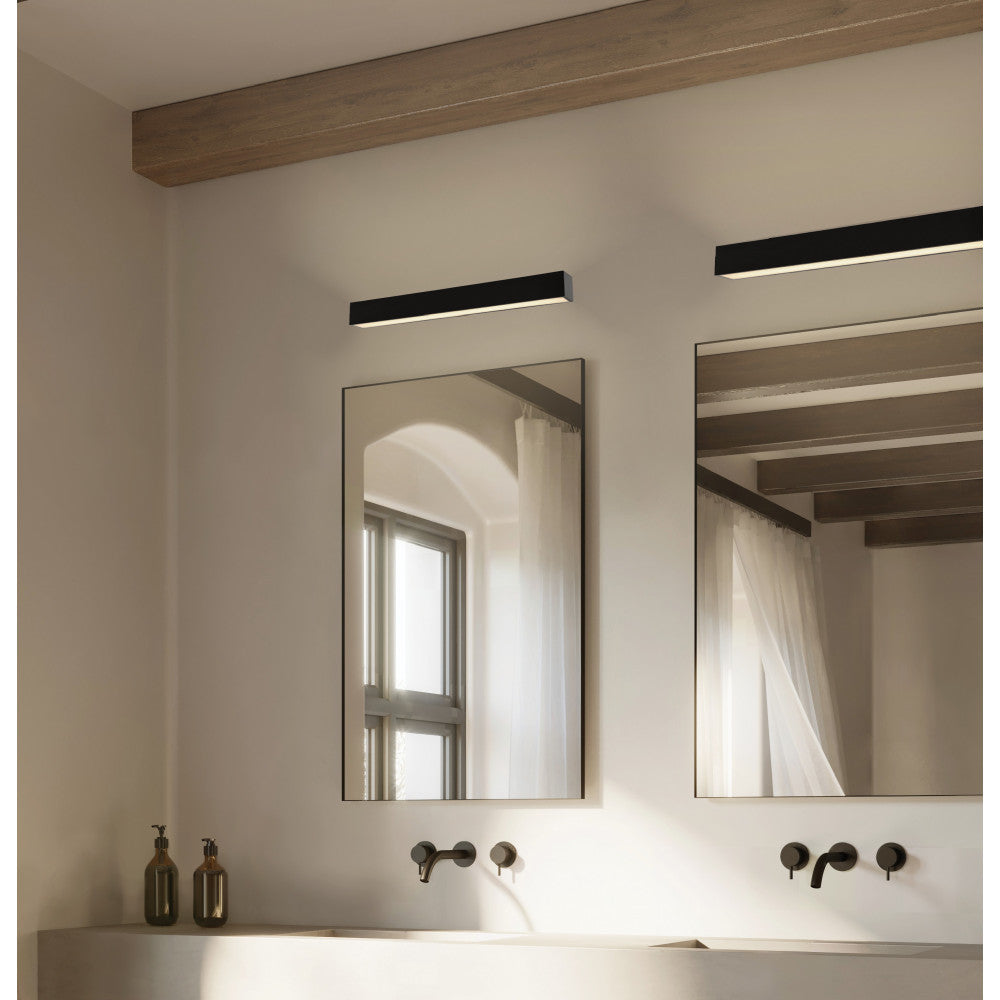 Vue rapprochée des miroirs surmontés des appliques, vasques et robinets muraux noirs