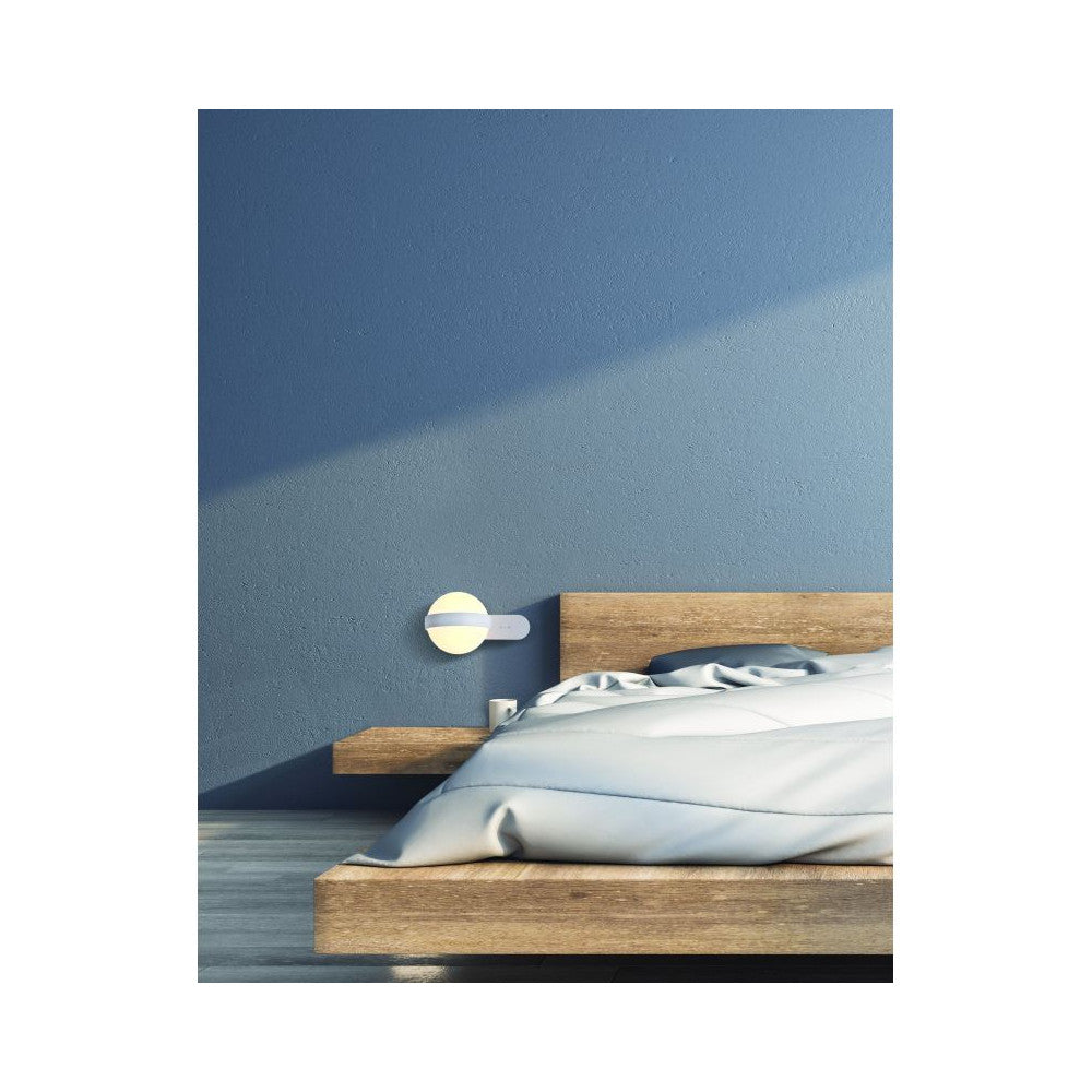 Mise en ambiance chambre, applique allumée au-dessus d'un chevet en bois