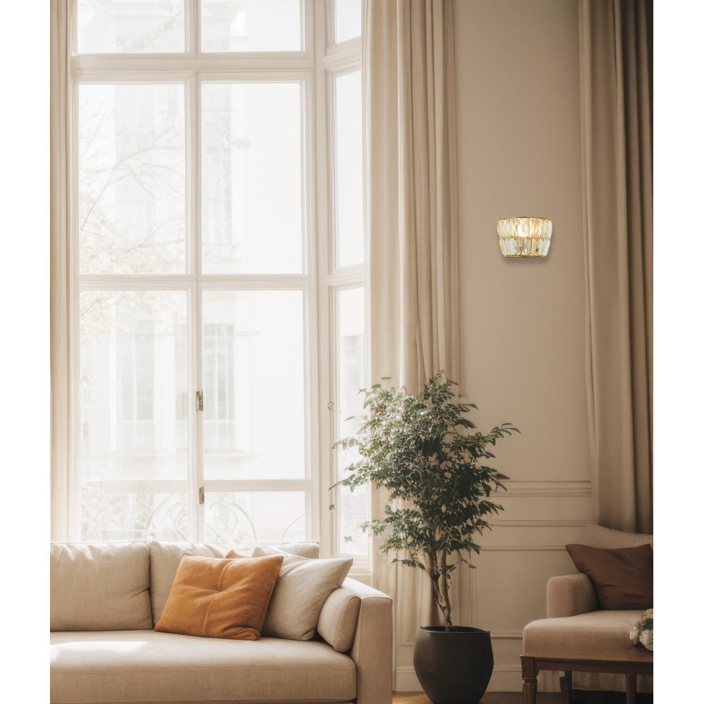 Applique murale laiton et cristal fixée sur mur beige près d'une fenêtre