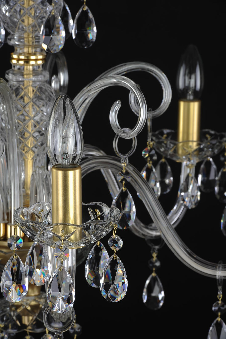 Détail d'une bobèche en cristal, douille dorée, ampoule et pendentifs facettés