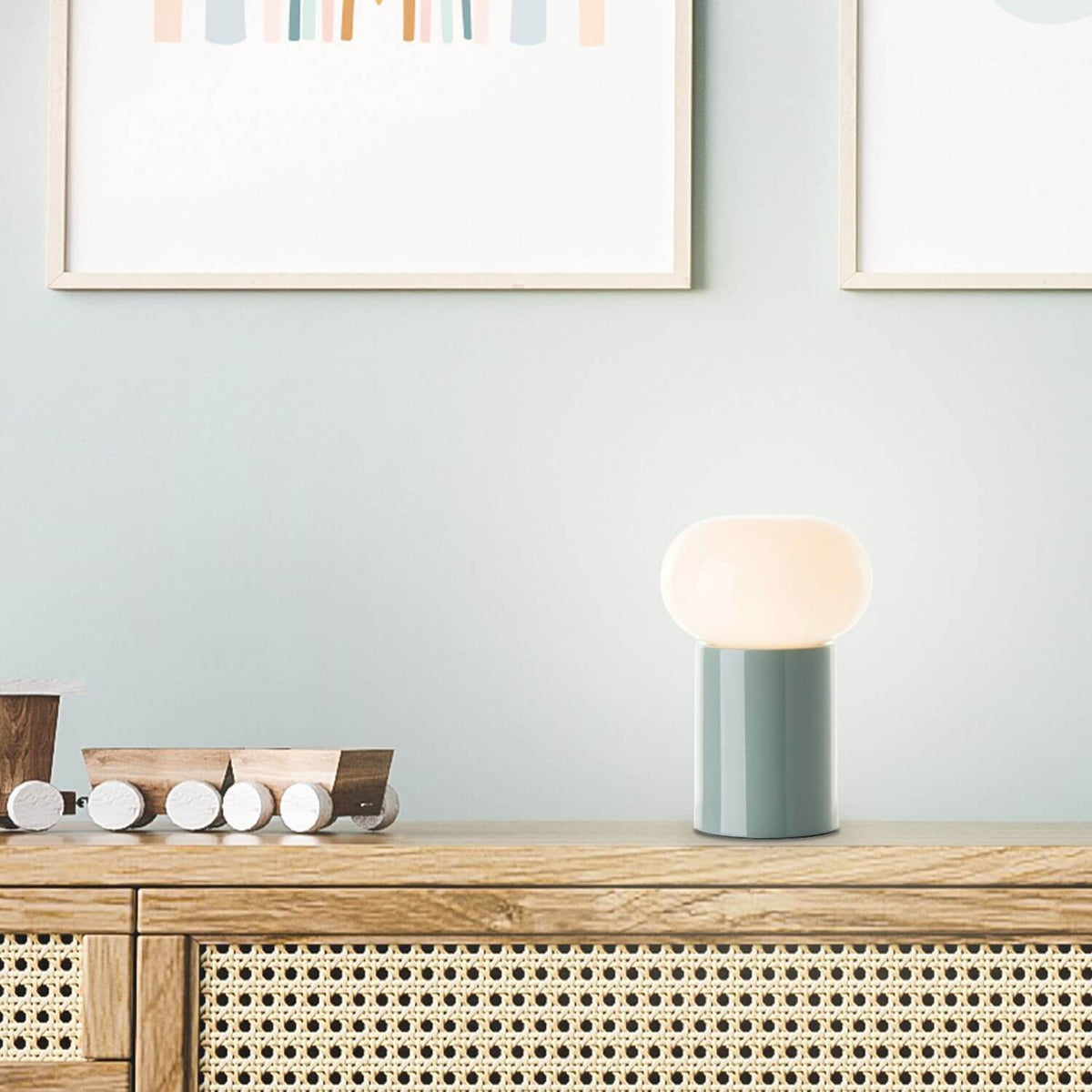 Lampe allumée sur un buffet en bois avec un petit train