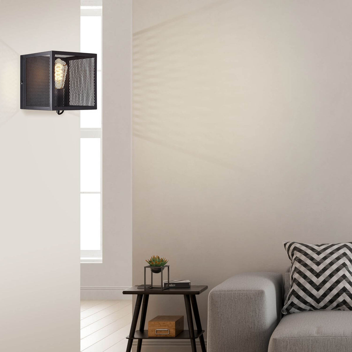 Mise en situation : applique murale noire éclairant un coin salon avec table et canapé.