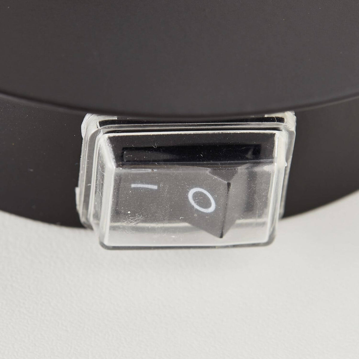 Gros plan sur l'interrupteur à bascule sous capot transparent intégré à la base