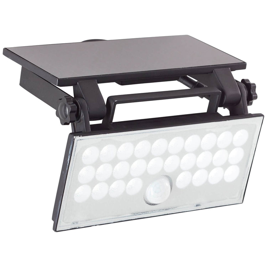 Vue de trois quarts du projecteur solaire incliné, panneau solaire noir et LED visibles.