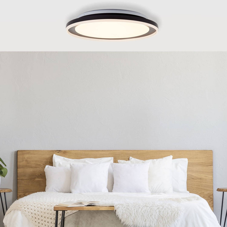 Ambiance dans une chambre, plafonnier allumé au-dessus d'un lit en bois clair