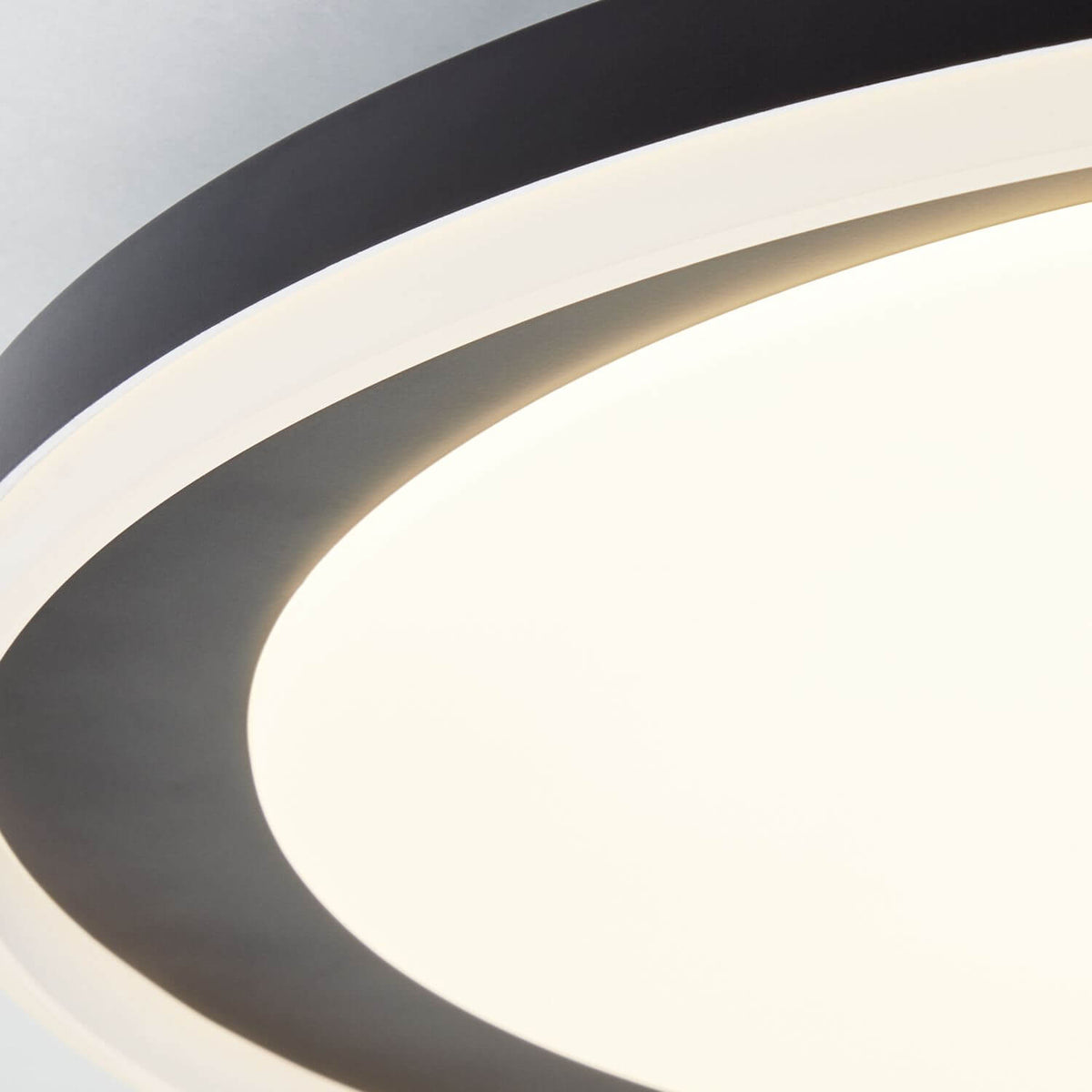 Détail rapproché du cerclage noir et du diffuseur blanc, lumière allumée