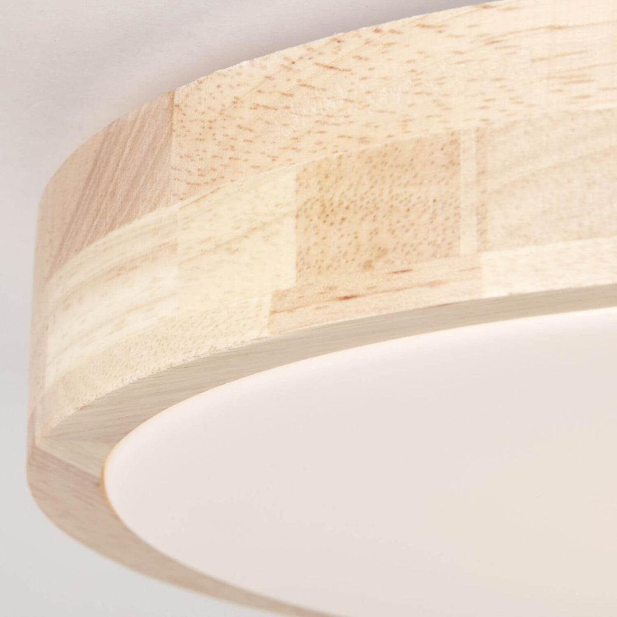 Détail macro de la finition du cerclage en bois et du diffuseur blanc