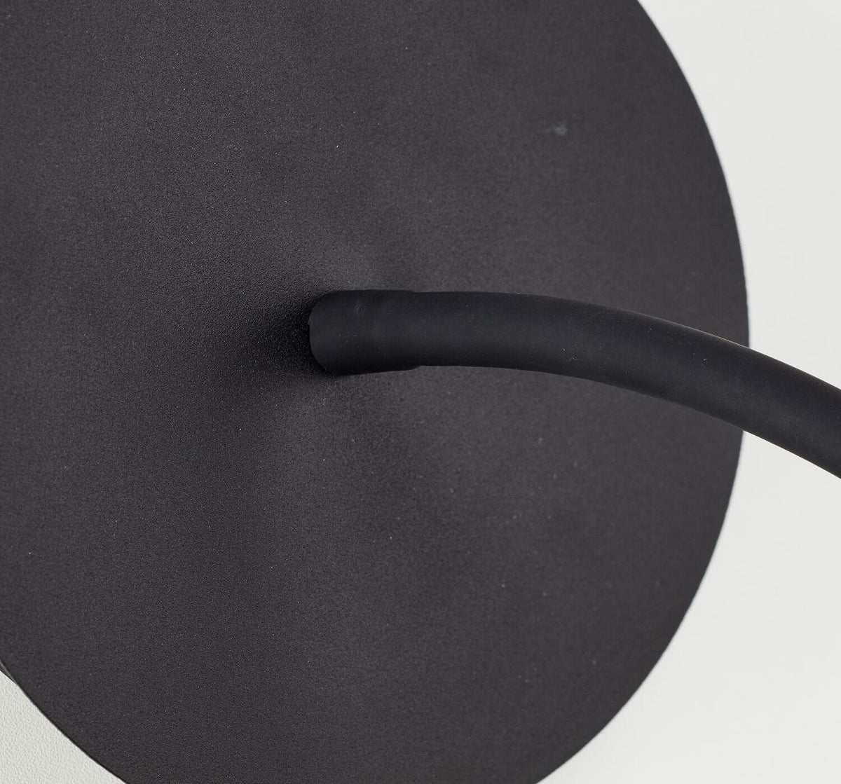 Gros plan sur la base ronde noire et l'attache du bras flexible