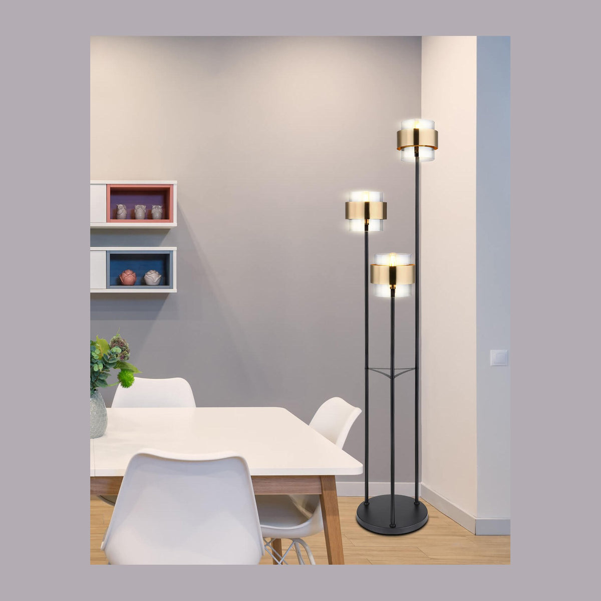 Lampadaire trois têtes installé dans une salle à manger, près d'une table blanche et chaises