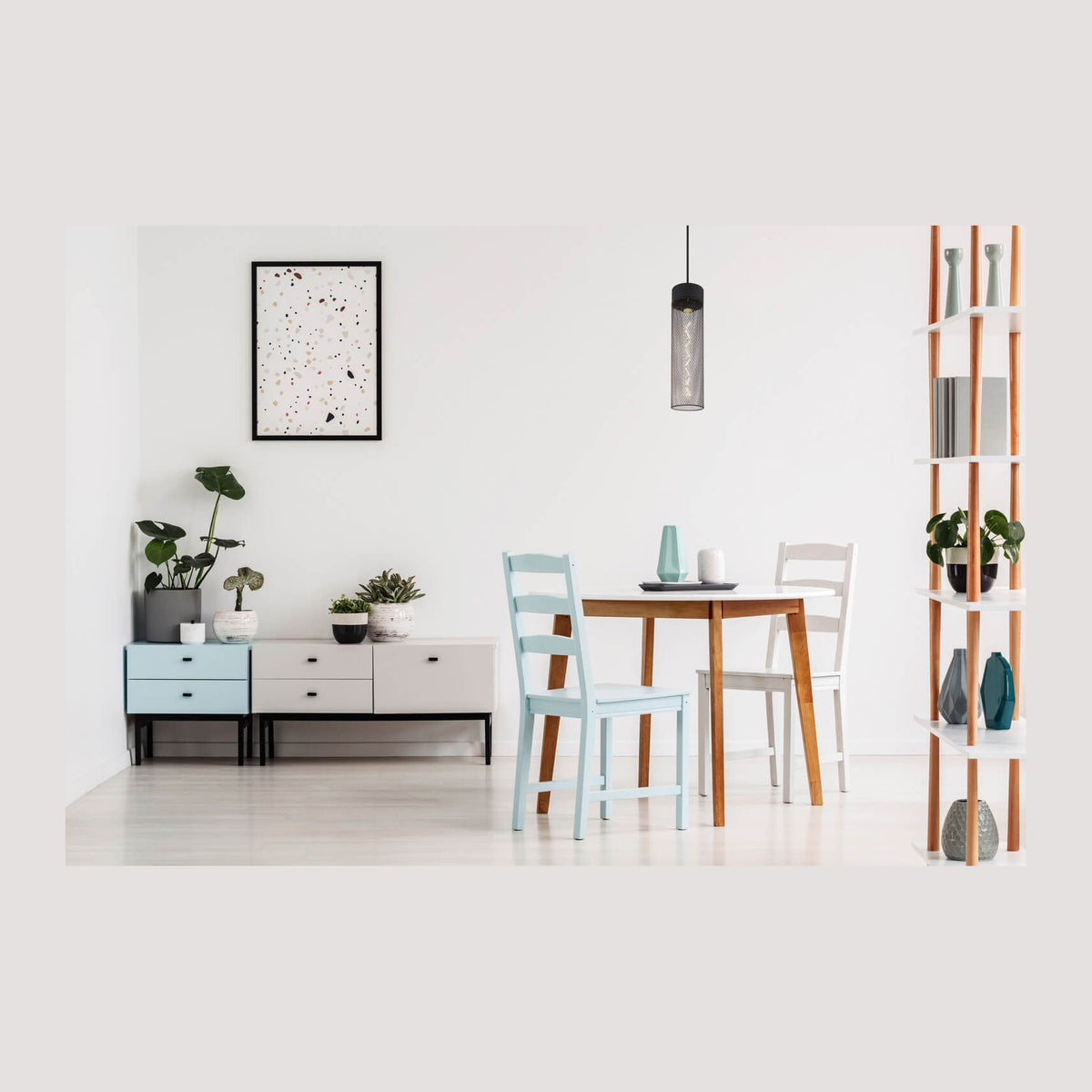 Suspension noire allumée au-dessus d'une table ronde dans un intérieur clair