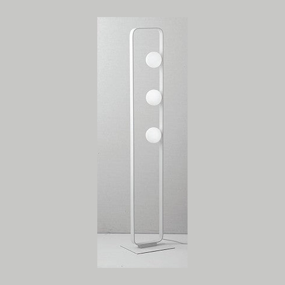 Lampadaire blanc de face sur fond gris, trois globes et cadre rectangulaire fin.