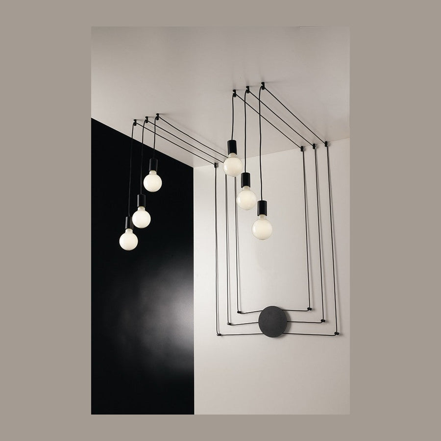 Vue d'ensemble du luminaire noir à six ampoules blanches suspendues par des câbles.