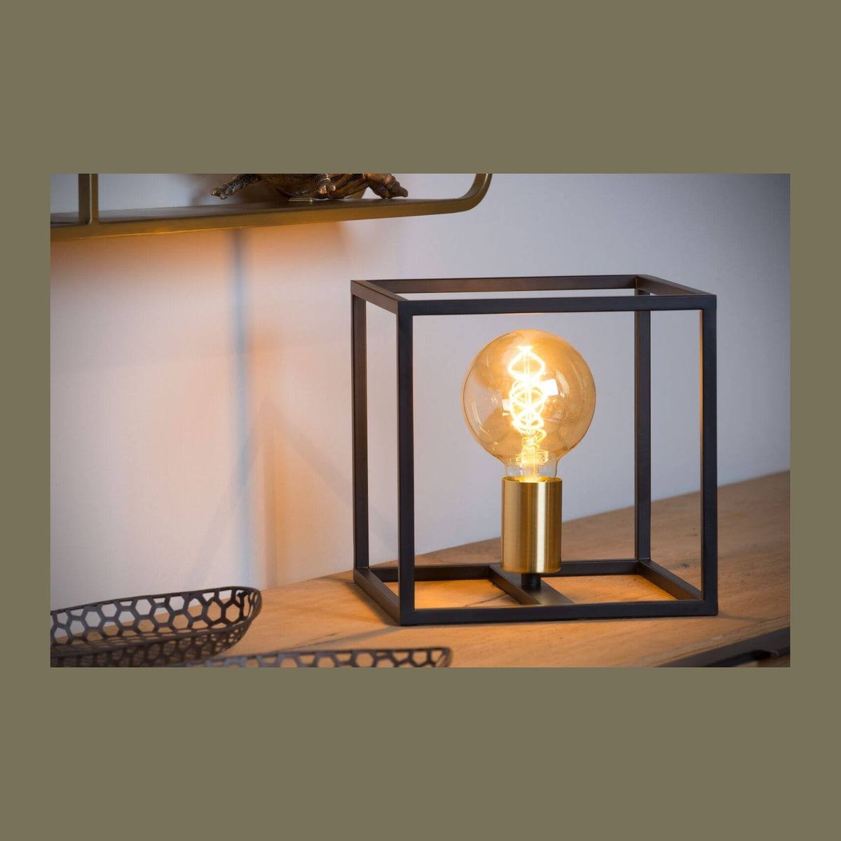 Lampe posée sur table en bois, ampoule allumée dans cadre noir carré