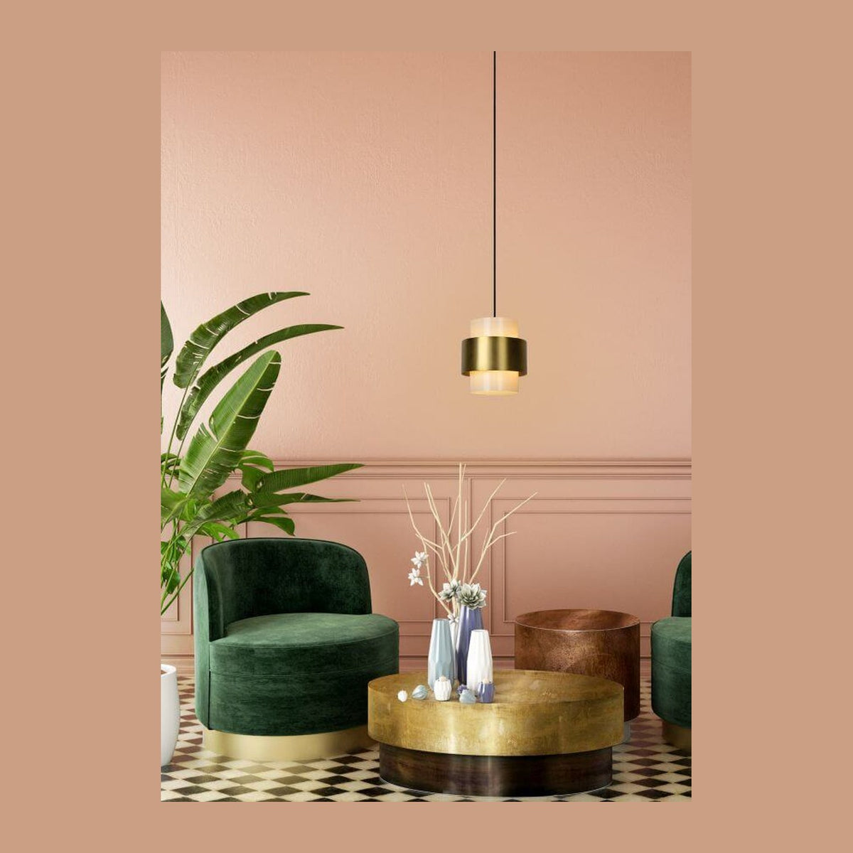 Vue en situation de la suspension dorée dans un salon rose avec fauteuils verts et table.