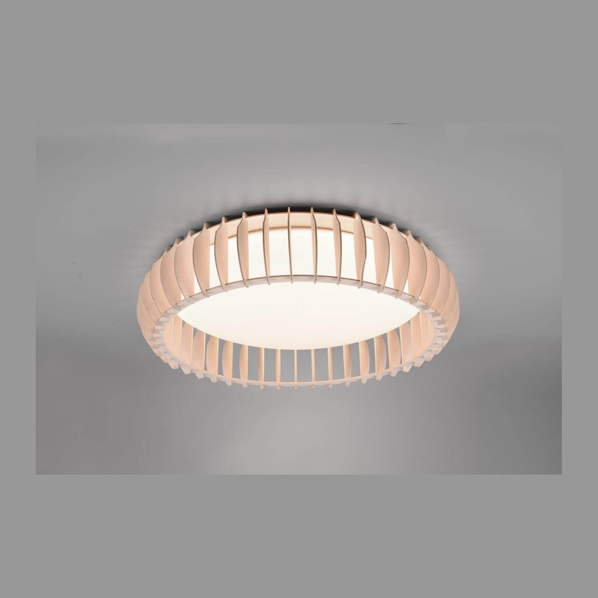 Luminaire rond blanc fixé au plafond, lumière allumée, lames verticales visibles.