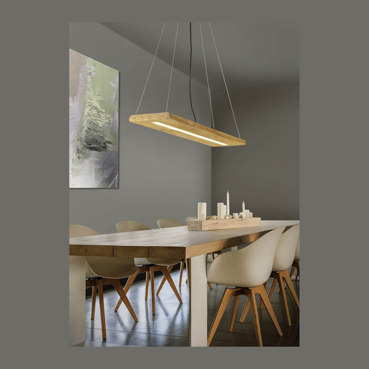 Suspension rectangulaire en bois clair suspendue au-dessus d'une table de salle à manger.