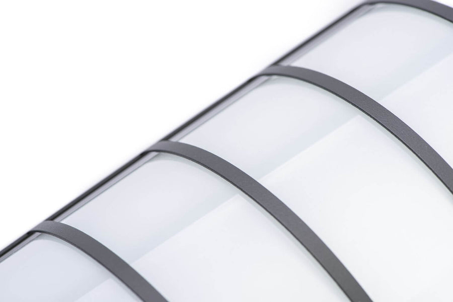 Détail rapproché du cadre métallique anthracite et du verre blanc incurvé de l'applique