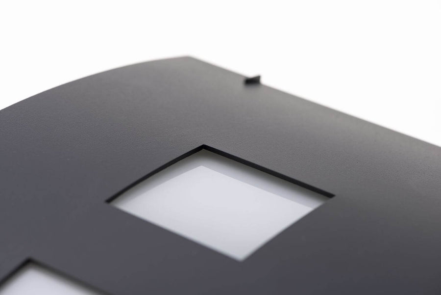 Détail de la finition granitée et d'une ouverture carrée au diffuseur blanc