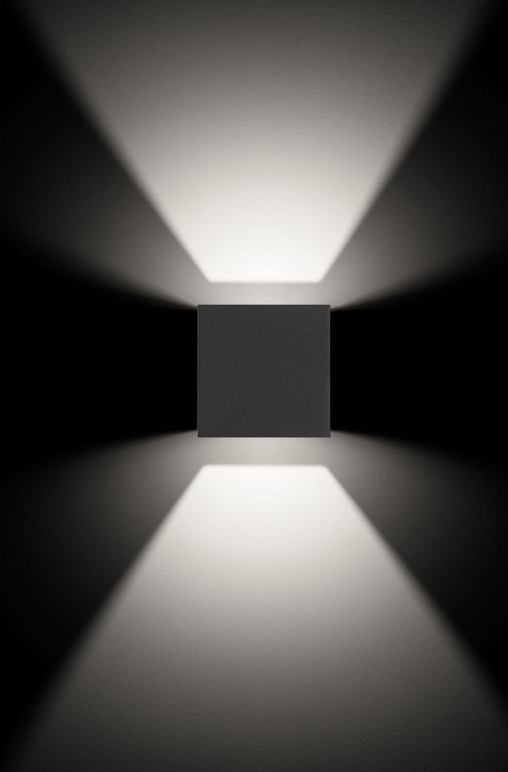 Mise en ambiance de face, applique noire projetant deux cônes de lumière opposés