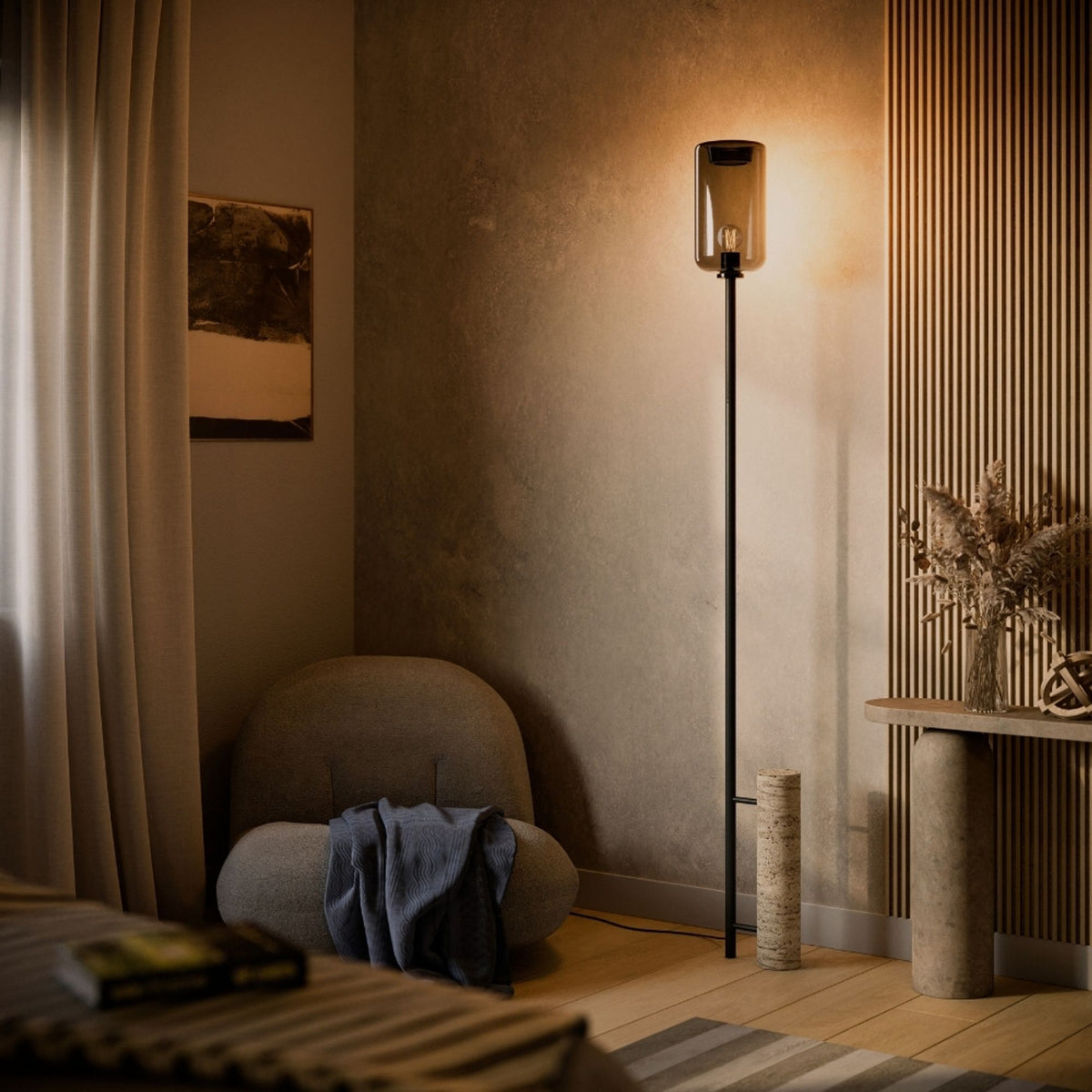 Lampadaire noir allumé dans un salon, pied en travertin posé au sol