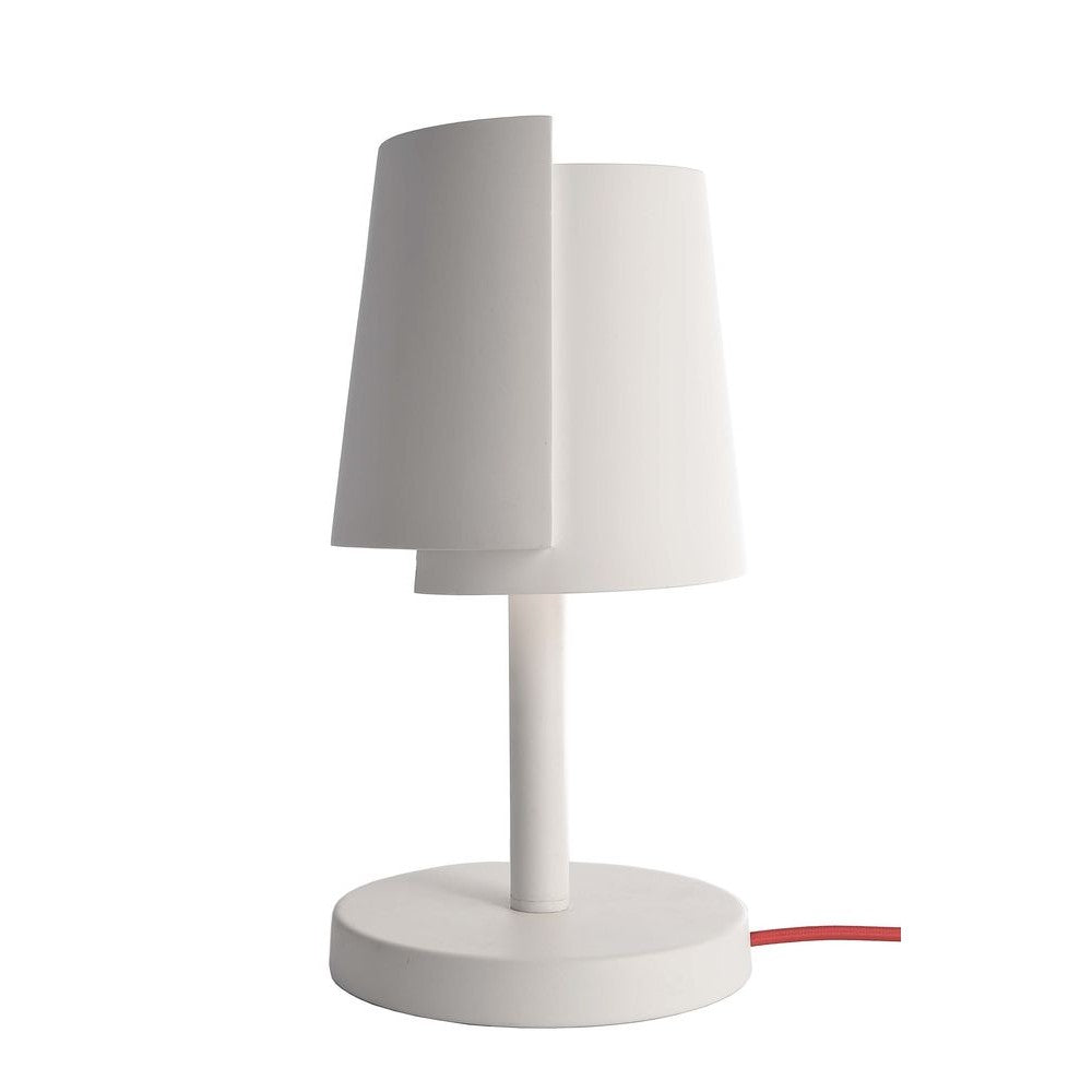 Lampe à poser blanche, abat-jour conique décalé et câble rouge apparent.