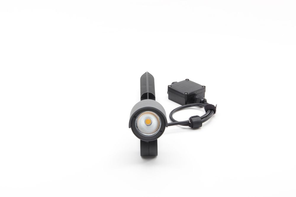 Vue de face du projecteur cylindrique allumé, lentille LED et boîtier de raccordement