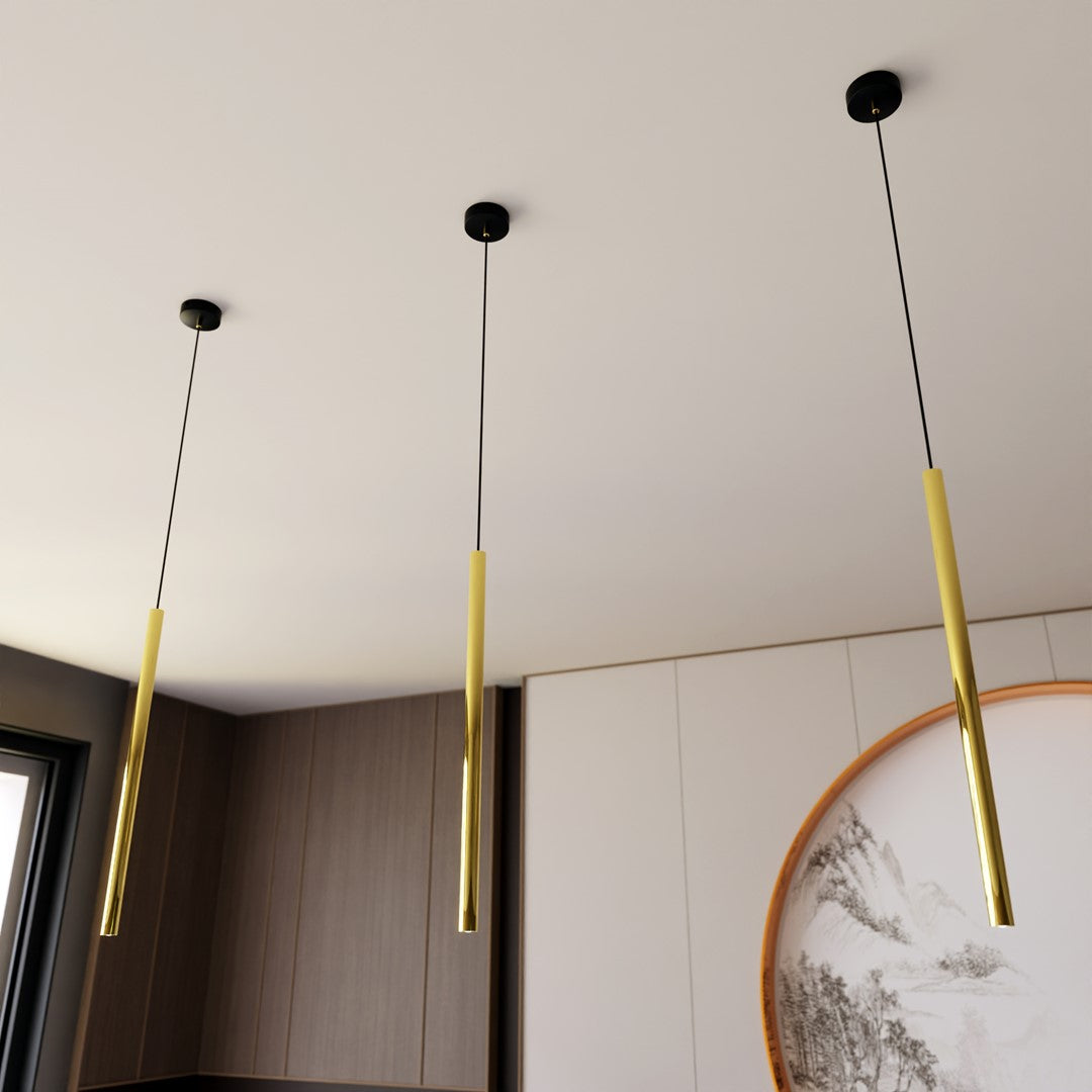 Vue en contre-plongée de trois suspensions dorées fixées au plafond blanc d’un intérieur.