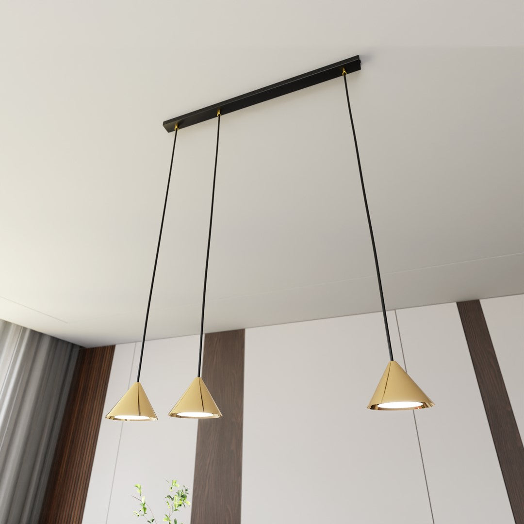 Vue en contre-plongée sous le plafond, barre noire et trois cônes dorés alignés.