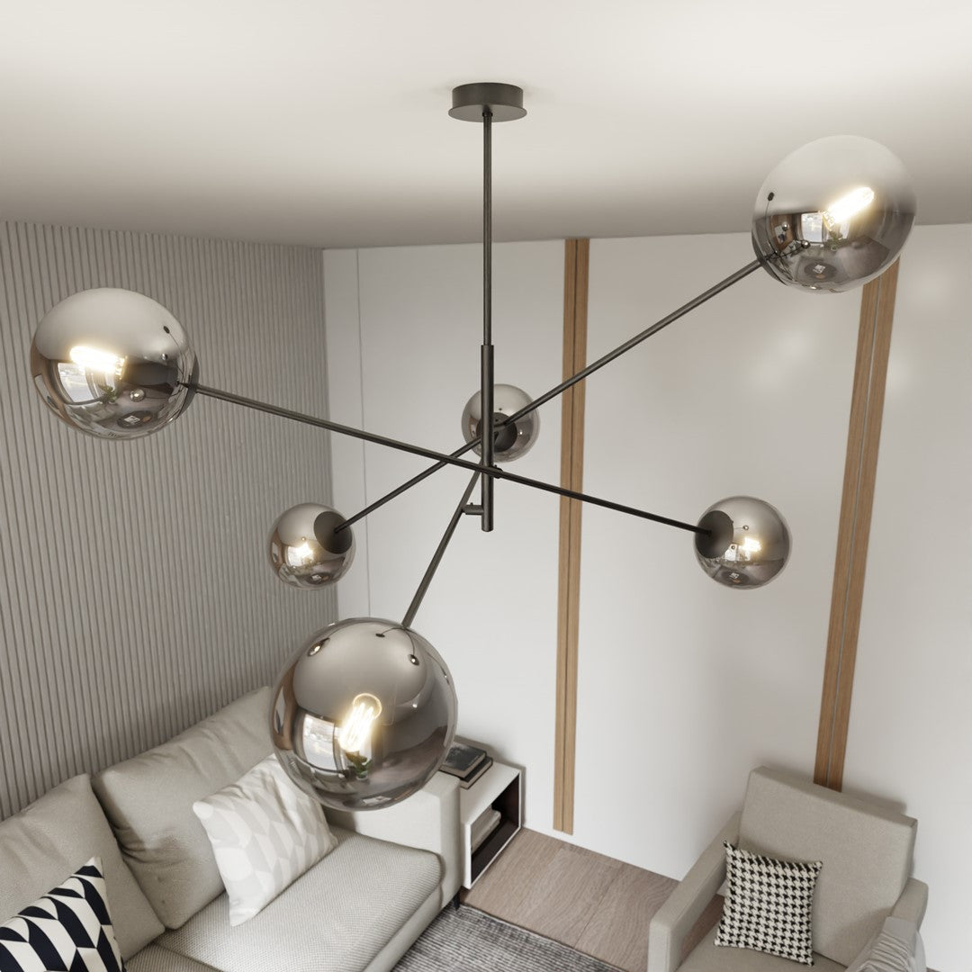 Vue en plongée du plafonnier, gros globes fumés devant le canapé et le fauteuil