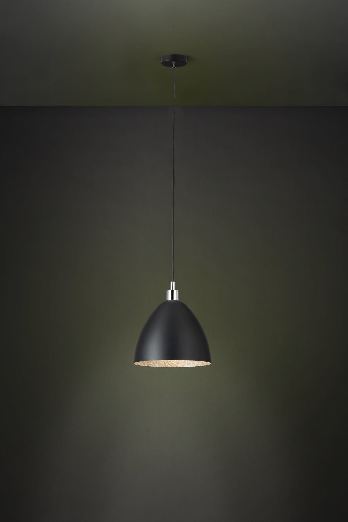 Suspension allumée dans un intérieur sombre, diffusant une lumière chaude sous l'abat-jour.