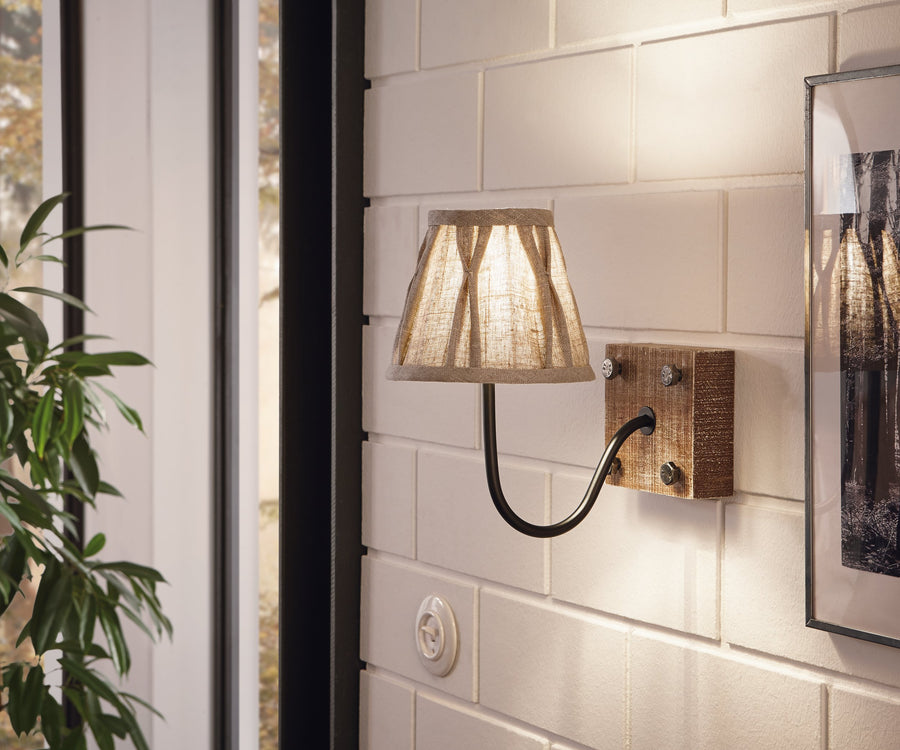 Applique allumée fixée sur mur de briques blanches, abat-jour conique en lin