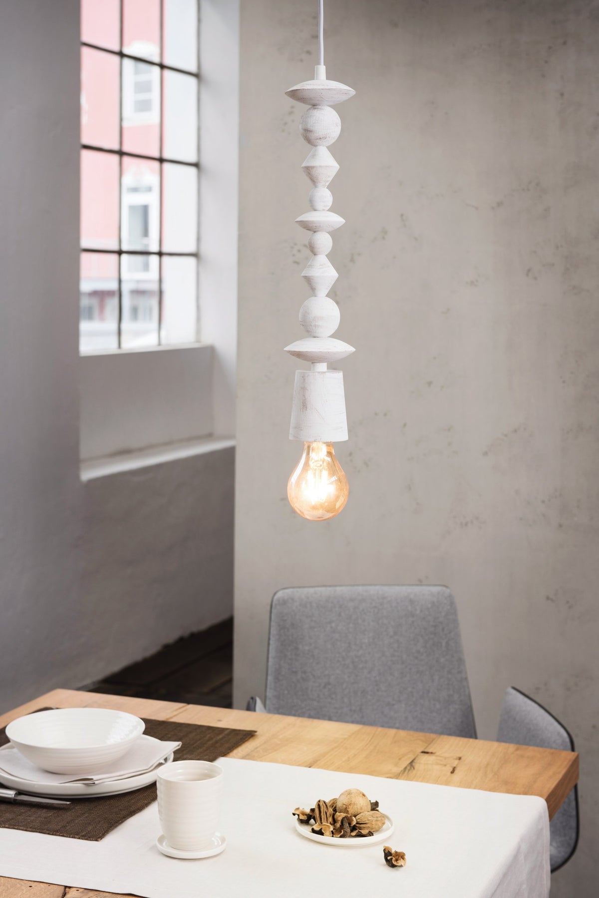Suspension allumée au-dessus d'une table dressée, ambiance salle à manger contemporaine