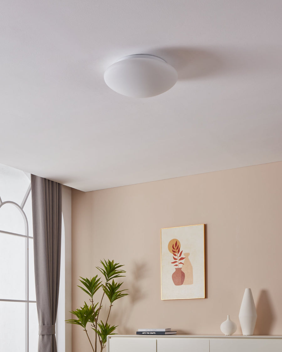 Luminaire blanc fixé au plafond dans un salon beige contemporain