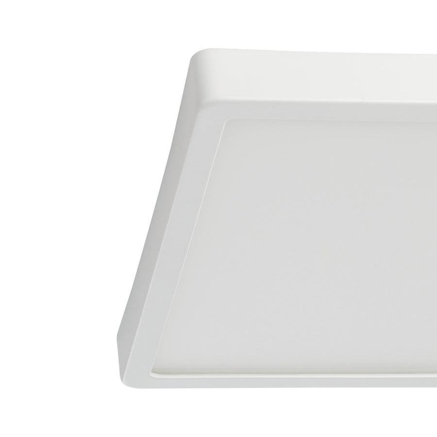 Gros plan sur l'angle et la bordure d'un luminaire carré blanc à diffuseur.