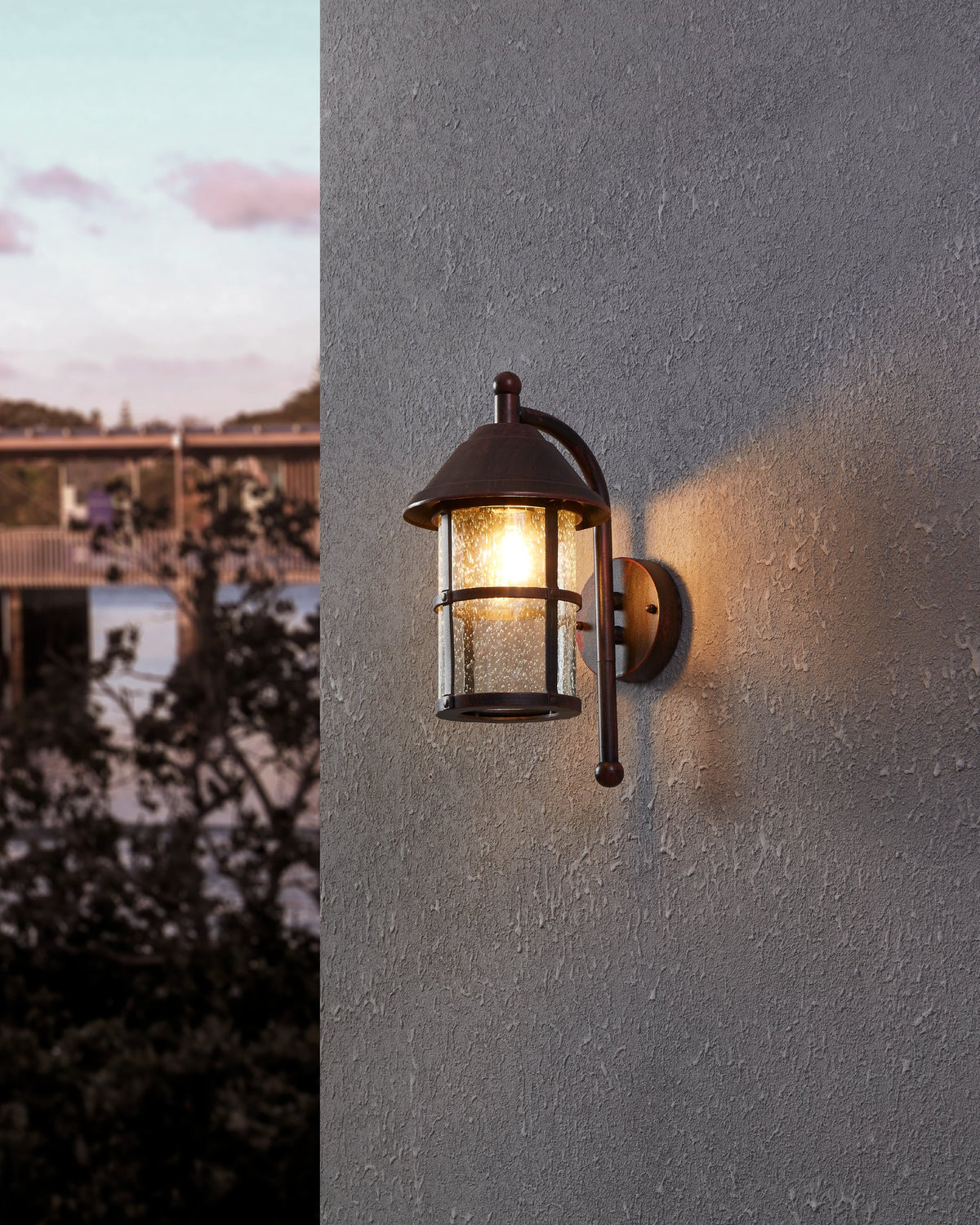 Mise en ambiance nocturne sur mur gris, lanterne allumée diffusant une lumière chaude
