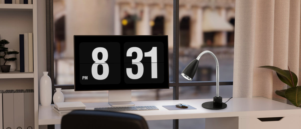 Lampe posée sur un bureau blanc devant un écran affichant 8:31.