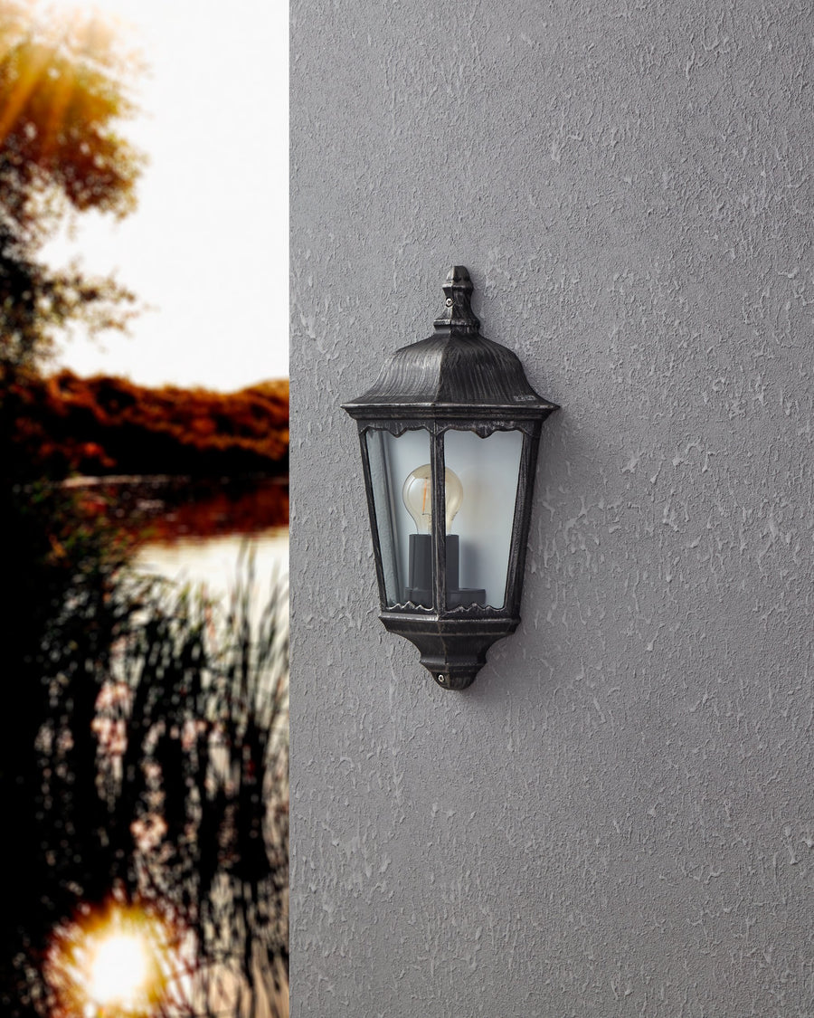 Vue rapprochée de l'applique éteinte sur mur gris, arrière-plan naturel flou