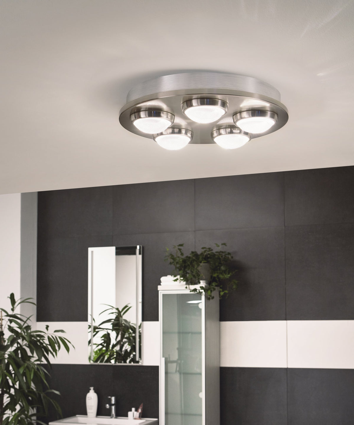 Mise en ambiance du plafonnier allumé au-dessus d'une salle de bain aux carreaux noirs