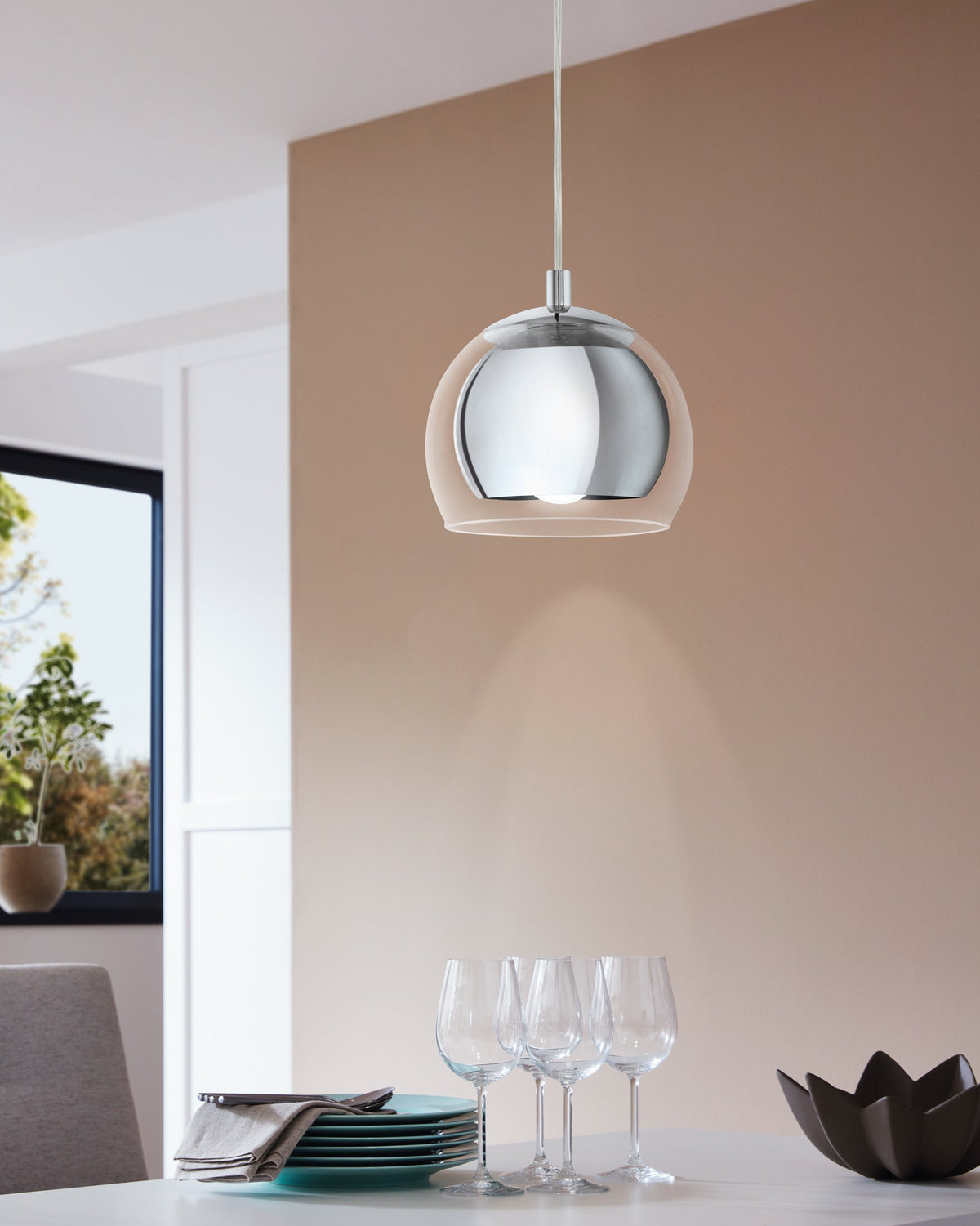Mise en ambiance au-dessus d'une table dressée avec verres à vin et assiettes empilées