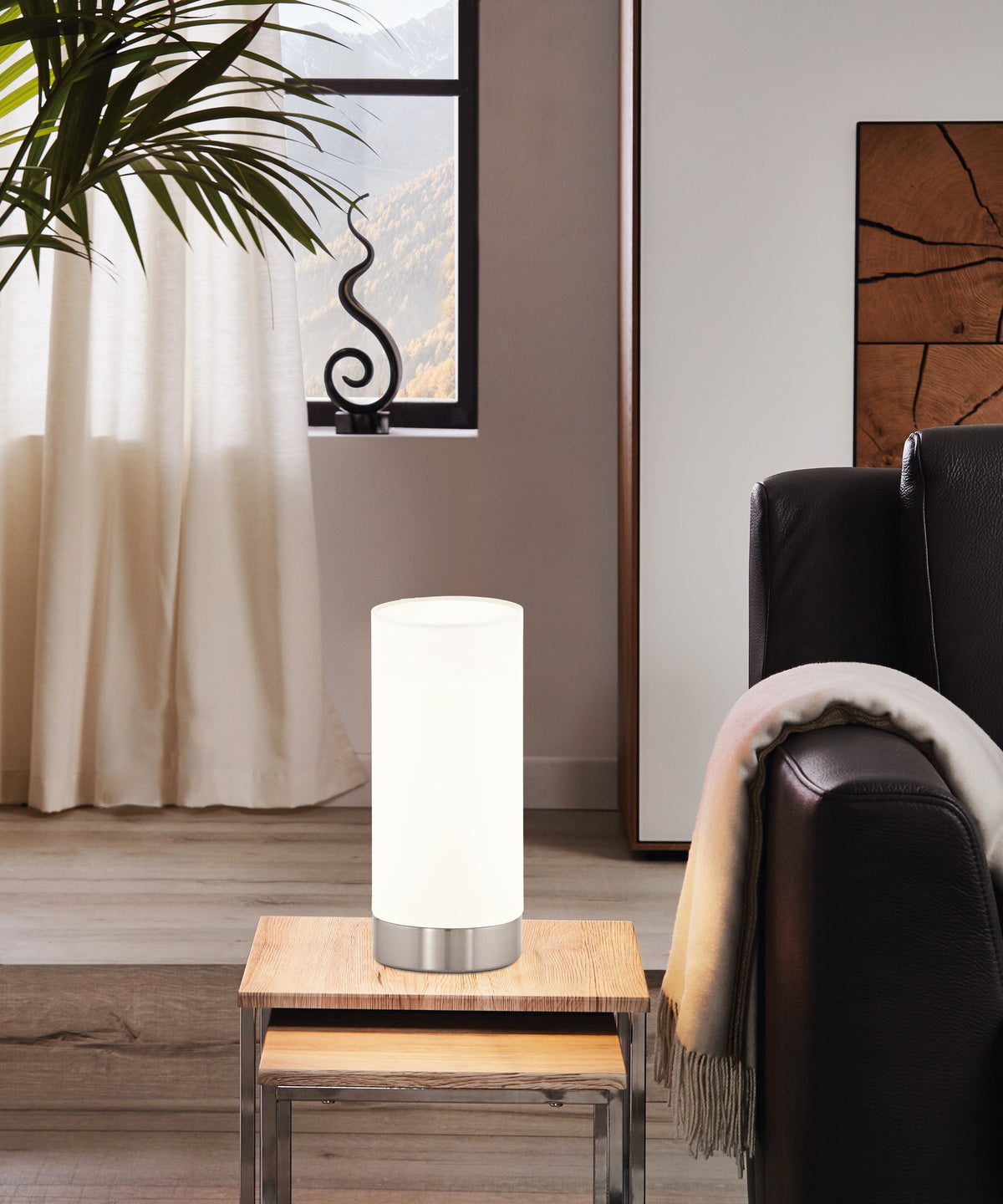 Mise en ambiance : lampe posée sur table basse près d'un canapé en cuir.