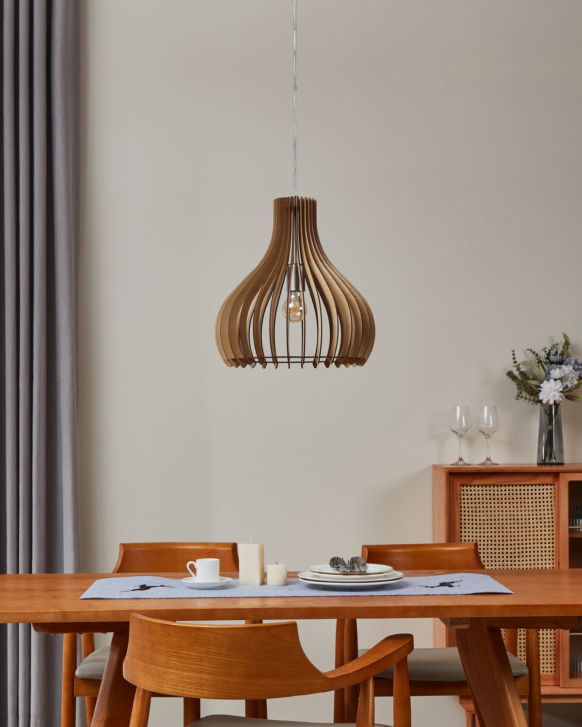 Suspension allumée au-dessus d'une table dressée dans un intérieur contemporain.