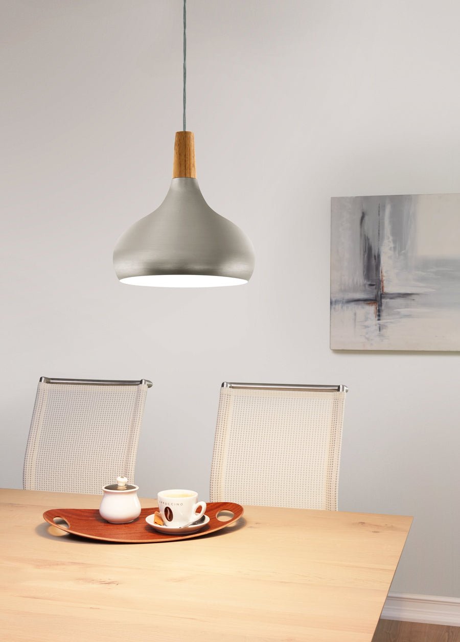 Luminaire suspendu au-dessus d'une table en bois avec plateau, tasse et chaises cannées.