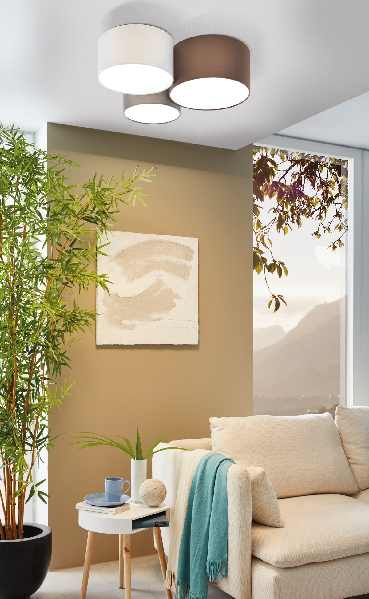 Mise en ambiance du plafonnier installé au plafond dans un salon beige avec plantes.