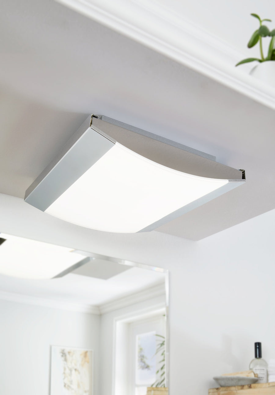 Luminaire allumé fixé au plafond dans une pièce blanche et lumineuse