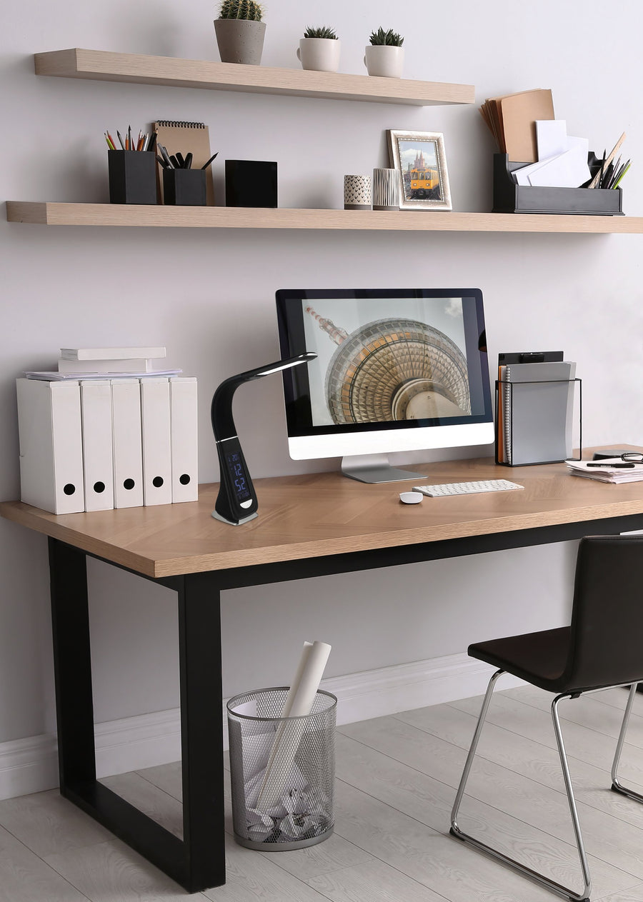 Mise en ambiance bureau : la lampe éclairée côtoie un écran, des classeurs et des étagères