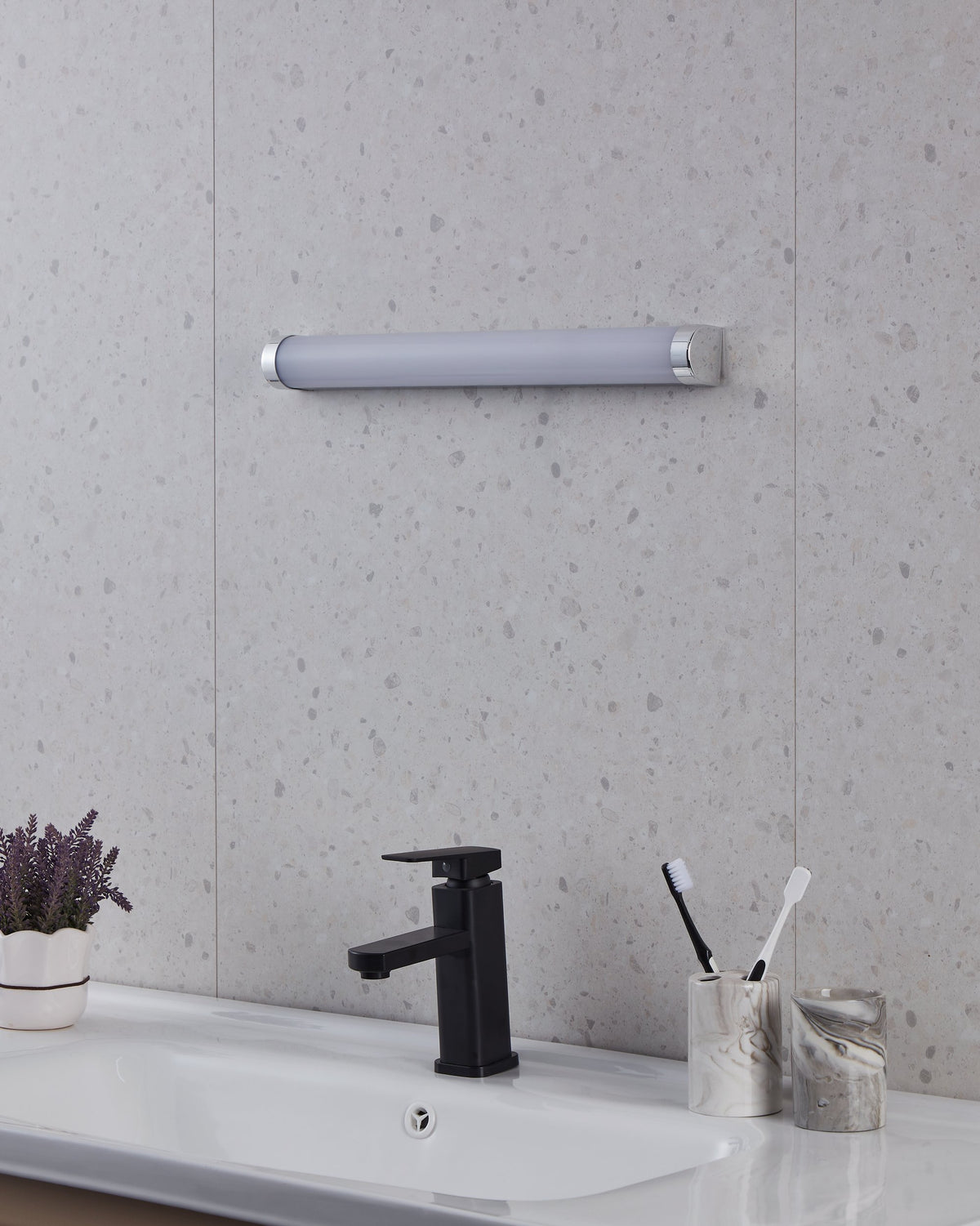 Même salle de bain, applique murale éteinte, tube gris et blanc sous un éclairage neutre.