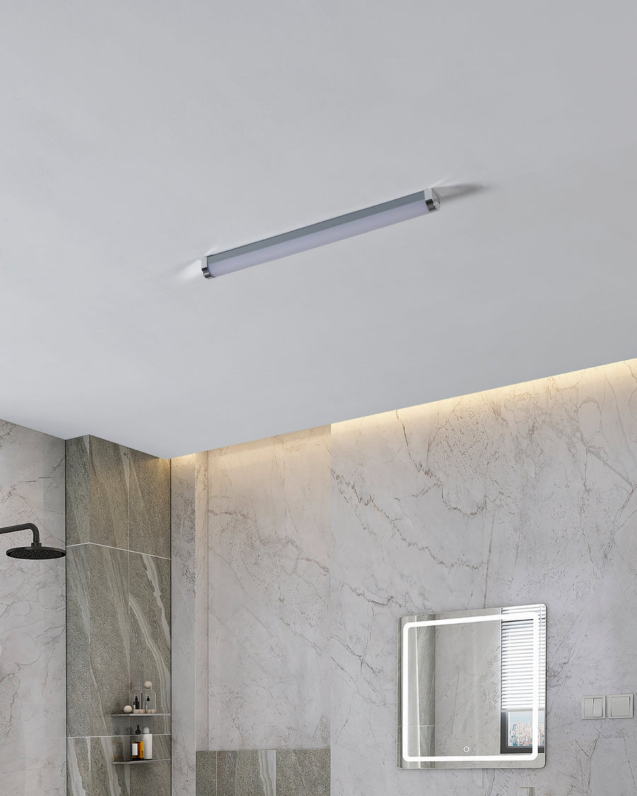 Luminaire fixé au plafond d'une salle de bain en marbre, éclairage diffus.
